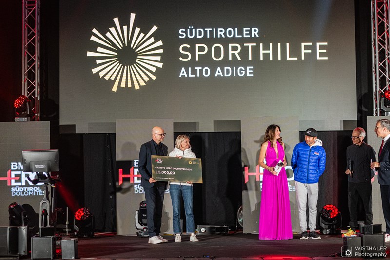 Im Rahmen der Charity Night überreichte OK-Chef Gerhard Vanzi der Südtiroler Sporthilfe, vertreten durch Sabine Oberhollenzer einen Scheck über 5.000 Euro. Foto: Harald Wisthaler